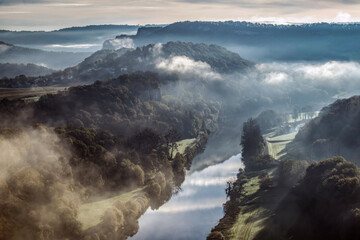 Rivière dans une vallée embrumée au lever du jour
