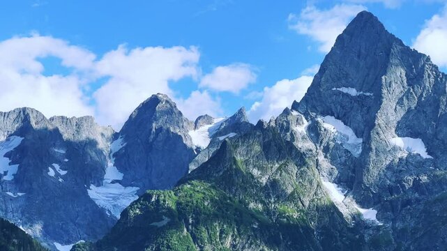 Teberdinsky Nature Reserve. View of Kosygin's glade in the Gonachkhir gorge and the top of Dombai-Ulgen mountain near Lake Tumanly-Kel on a sunny summer day. Panoramic landscape. Resort. 4K