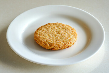 A Round, Golden Wheat Biscuit on a Simple Ceramic Plate.