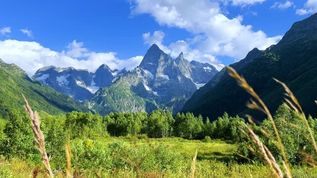 Teberdinsky Nature Reserve. View of Kosygin's glade in the Gonachkhir gorge and the top of Dombai-Ulgen mountain near Lake Tumanly-Kel on a sunny summer day. Panoramic landscape. Resort. 4K