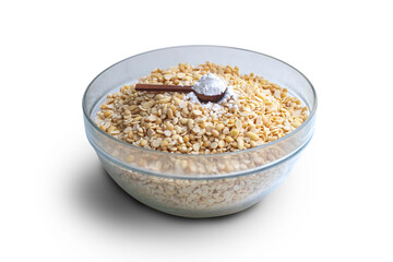 Cook soybean (soy bean, soya bean, Glycine max) in glass bowl with a wooden scoop of tempeh starter isolated on white background with clipping path close up