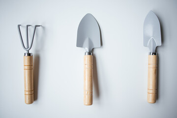 Set of three gardening tools with wooden handles on white background
