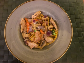Rice noodles with chicken and champignons is a traditional Chinese dish.