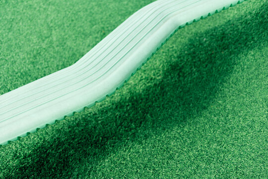Balancing beam resting on green artificial turf in playground setting