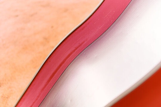 Red and white inflatable slide detail on sandy beach