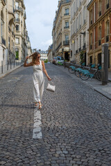Elegant woman walking up a charming cobblestone street in Paris