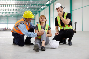 senior worker fall down on the floor with hurting knee and coworker helping her in the factory