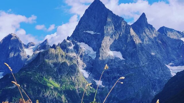 Teberdinsky Nature Reserve. View of Kosygin's glade in the Gonachkhir gorge and the top of Dombai-Ulgen mountain near Lake Tumanly-Kel on a sunny summer day. Panoramic landscape. Resort. 4K