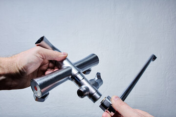Assembling bathroom faucet with secure threaded spout attachment.