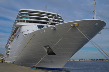 Luxury classic cruiseship cruise ship liner Romantica docked in port of Messina, Sicily in Italy during Winter Mediterranean Greek Island cruising with Strait of Messina and coastline in background