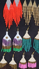 Vertical image of Colorful traditional beaded earrings for sale at the Otavalo Market, Ecuador