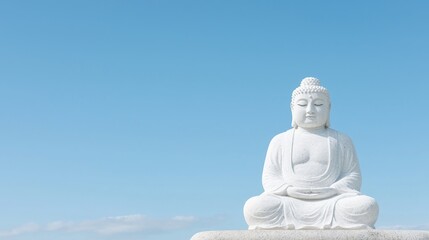Obraz premium Peaceful Buddha statue against a clear sky. Outdoor serene scene. Potential use Meditation, spirituality, or religion stock photo
