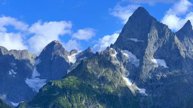 Teberdinsky Nature Reserve. View of Kosygin's glade in the Gonachkhir gorge and the top of Dombai-Ulgen mountain near Lake Tumanly-Kel on a sunny summer day. Panoramic landscape. Resort. 4K