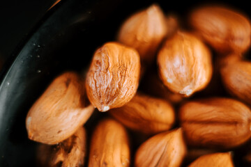Delicious hazelnuts served in a plate on a simple black background for a close-up culinary experience