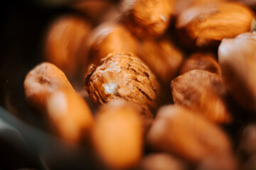 Hazelnuts displayed in a black plate contrasting with natural textures