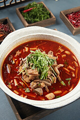 Spicy lamb offal soup in stone pot with red oil