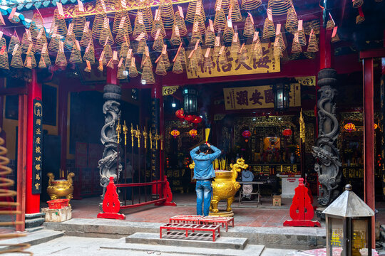 Ho Chi Minh city, Vietnam - February 4th, 2025: The people are visiting the Thien Hau Pagoda, a famous Chinese temple. Everyone is burning incense and bowing to pay respects to the divine