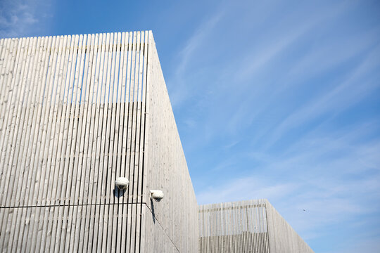 Modern building exterior with wooden cladding and security cameras