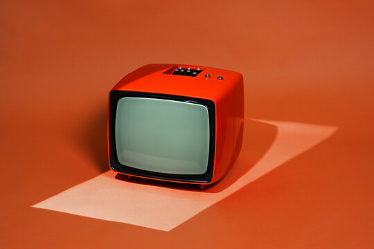 Retro orange old television on orange background
