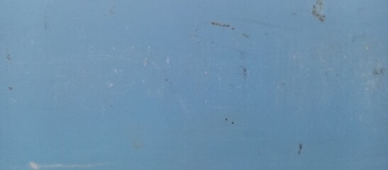 Blue wall, dirt on the wall gives it a somewhat dirty or worn appearance