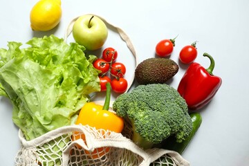 String bag with vegetables and fruits on gray background