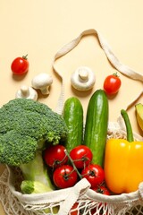 String bag with vegetables and fruits on color background
