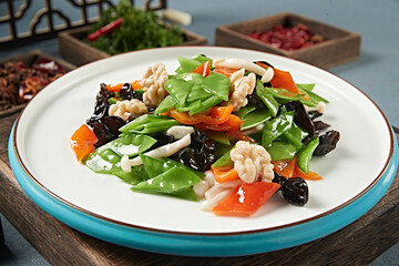 Stir-fried snow peas, bell peppers, black fungus, seafood, mushrooms and peach kernels