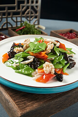 Stir-fried snow peas, bell peppers, black fungus, seafood, mushrooms and peach kernels