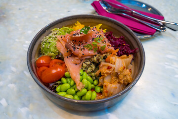 Healthy poke bowl with smoked salmon, quinoa, and fresh vegetables