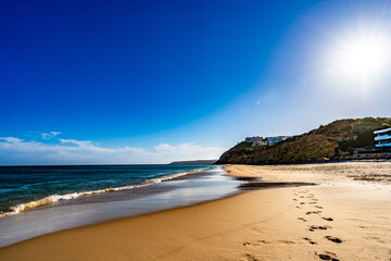 Empty Amado beach in Portugal. Beautiful Algarve coast. View at sunny and sandy beach and cliff