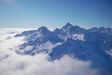 Fototapeta premium Snow-covered peaks of the Swiss Alps rise majestically above a sea of fluffy clouds under the clear blue sky, The Swiss alps from above - the beautiful nature of Switzerland - aerial timelapse shot
