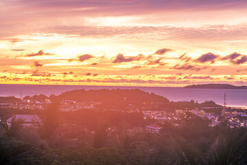 Morning nature background on a high mountain overlooking the sky above the sea with bright colors according to the time of the changing sun rising, surrounded by beautiful trees of various sizes.