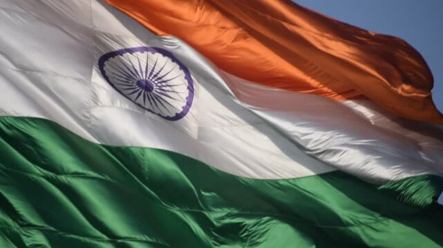 India flag flying high at Connaught Place with pride in blue sky, India flag fluttering, Indian Flag on Independence Day and Republic Day of India, tilt up shot, Waving Indian flag, Har Ghar Tiranga