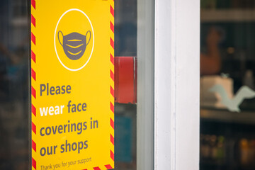 Face coverings warning sign displayed outside a shop in Southwold, UK