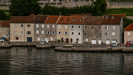 Obraz premium Row of Quaint Riverside Stone Buildings With a Scenic Waterfront View