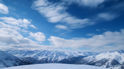 Naklejka premium Majestic snow covered mountains under bright blue sky with fluffy clouds. serene landscape evokes sense of tranquility and adventure, perfect for winter sports enthusiasts