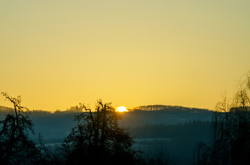 Golden Sunset Over Hills and Trees
