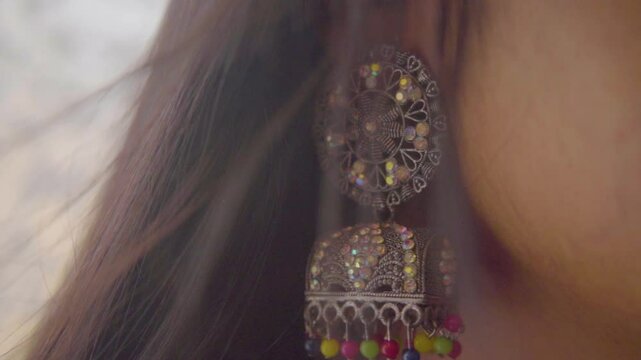 Closeup of woman wearing a tradition earring, slow motion shot
