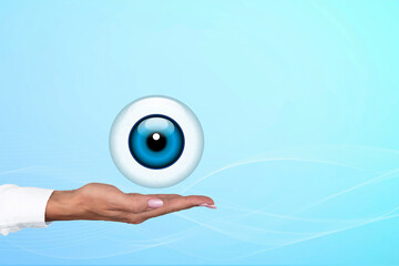 Human eye as a round icon on the palm of a woman doctor. Gradient blue background. Copy space.
