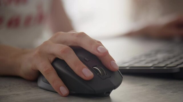 Woman using a computer mouse while working