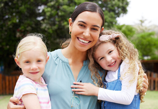 Outdoor, teacher and children in portrait for kindergarten, kids growth and relationship development. Playground, woman and students with support for wellness, childhood game and education with hug - Powered by Adobe