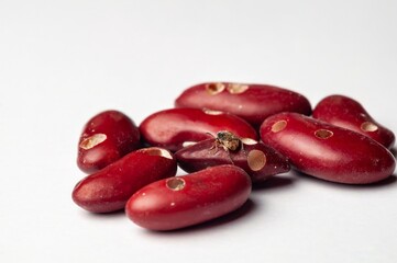 Tiny beetle crawling on kidney beans damaged by pests, highlighting food storage problems.