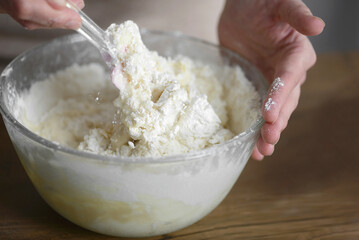 a woman kneads the dough for baking with a spatula, macro