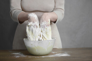 a woman kneads the dough with her hands