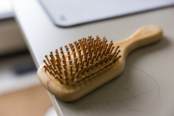 Wooden hairbrush with visible signs of hair loss
