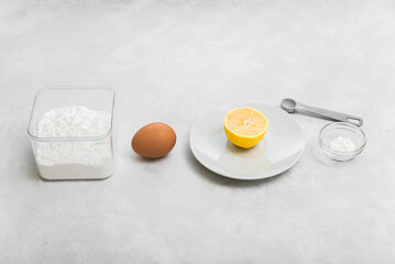 Ingredients for making icing (sugar glaze for cookies and gingerbread): powdered sugar, egg, lemon