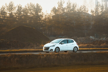 Compact car traveling on peaceful rural road