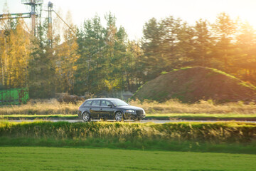 Fototapeta premium Black car on sunny rural road