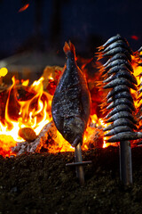 sardines and fish on the fire pierced with a sword, typical of Malaga, they are called espetos