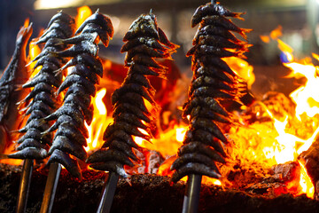 sardines and fish on the fire pierced with a sword, typical of Malaga, they are called espetos